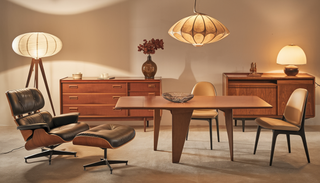 A sophisticated Mid-Century Modern dining room featuring iconic furniture pieces like an Eames Lounge Chair, George Nelson Dresser, Paul McCobb Credenza, and a Nakashima table, illuminated by a Bill Curry Lamp.