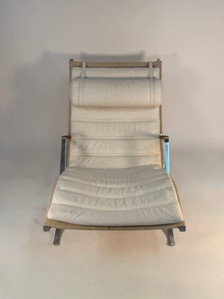 Beige lounge chair with metal frame on a plain background