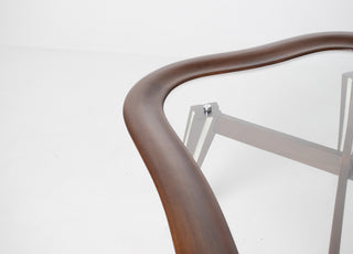 Three-quarter aerial view of Filippo Chissotti walnut cocktail table showing biomorphic frame, recessed glass panel, and X-pattern chrome bracing below, Italian postwar modernist design