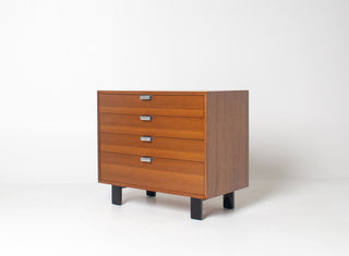 Three-quarter view of authentic George Nelson Basic Cabinet Series dresser showing walnut case, rift-sawn walnut drawer fronts, and black lacquered legs.
