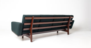 Rear view of authentic Hans Wegner GE-236 four-seat teak sofa for Getama Denmark with exposed slatted teak back and Maharam Gemma Caliber dark green upholstery.