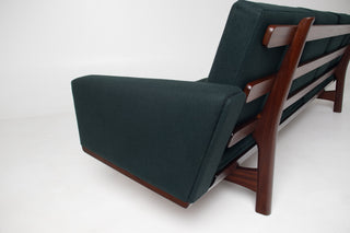 Side profile of Hans Wegner GE-236 four-seat Danish Modern sofa highlighting the solid teak frame and clean Scandinavian lines.