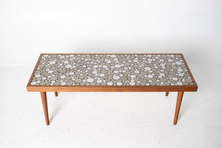 walnut coffee table with a coin mosaic table top on a white background