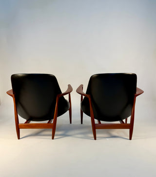 Back view of pair of black leather chairs designed by Ib Kofod Larsen.