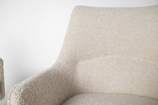 Close-up of a textured beige armchair against a white background
