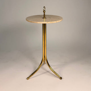 Small round table with marble top and brass base on a plain background