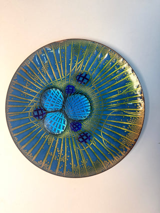 Decorative plate with blue and gold design on a white background