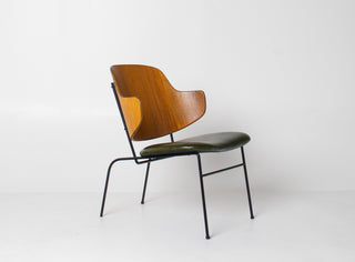Scandinavian Modern Chair in teak and green leather with metal legs.