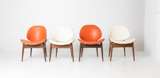Front view of four vintage Seymour James Weiner Kodawood clam shell dining chairs with walnut frames and original upholstery.