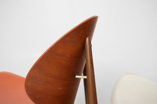 Close-up of walnut frame and original orange upholstered shell seat on vintage Kodawood dining chair.