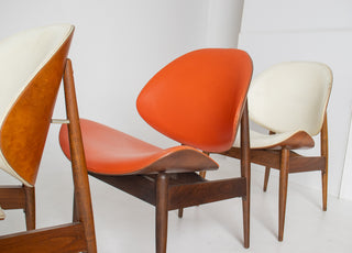 Side profile of four Seymour James Weiner Kodawood clam shell dining chairs showing sculptural walnut frames and floating backrests.