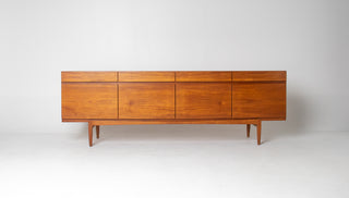 Ib Kofod-Larsen Model 66 teak credenza for Faarup Møbelfabrik featuring sculpted lower stretcher and sliding doors.