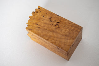 Overhead view of Michael Elkan Studio burl wood box lid showing figured grain pattern and raw natural edge erupting from one end
