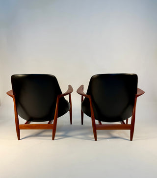 Back view of pair of black leather chairs designed by Ib Kofod Larsen.
