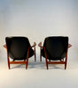Back view of pair of black leather chairs designed by Ib Kofod Larsen.