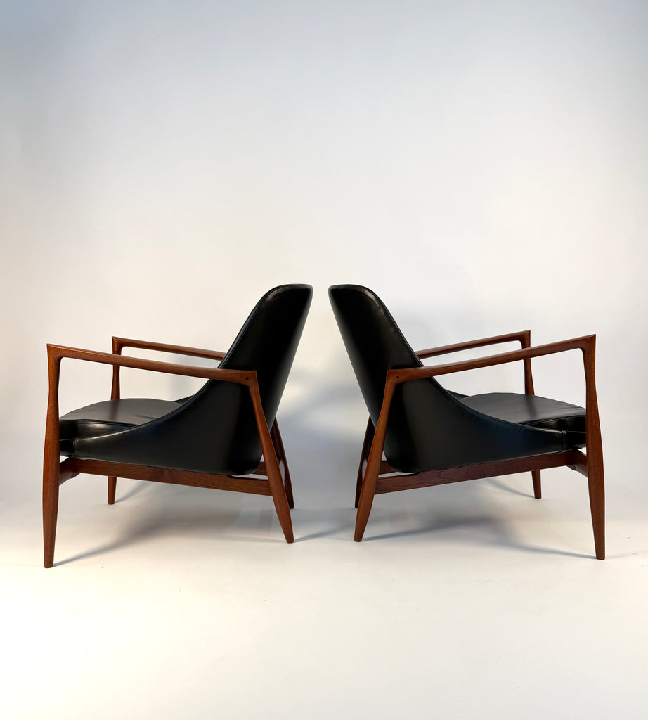 Pair of teak and black leather Elizabeth chairs from 1952 in profile. 