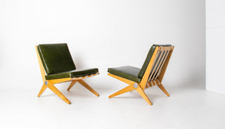 Two green cushioned chairs with wooden frames on a white background