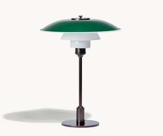 Table lamp with green glass shade and black base on a white background