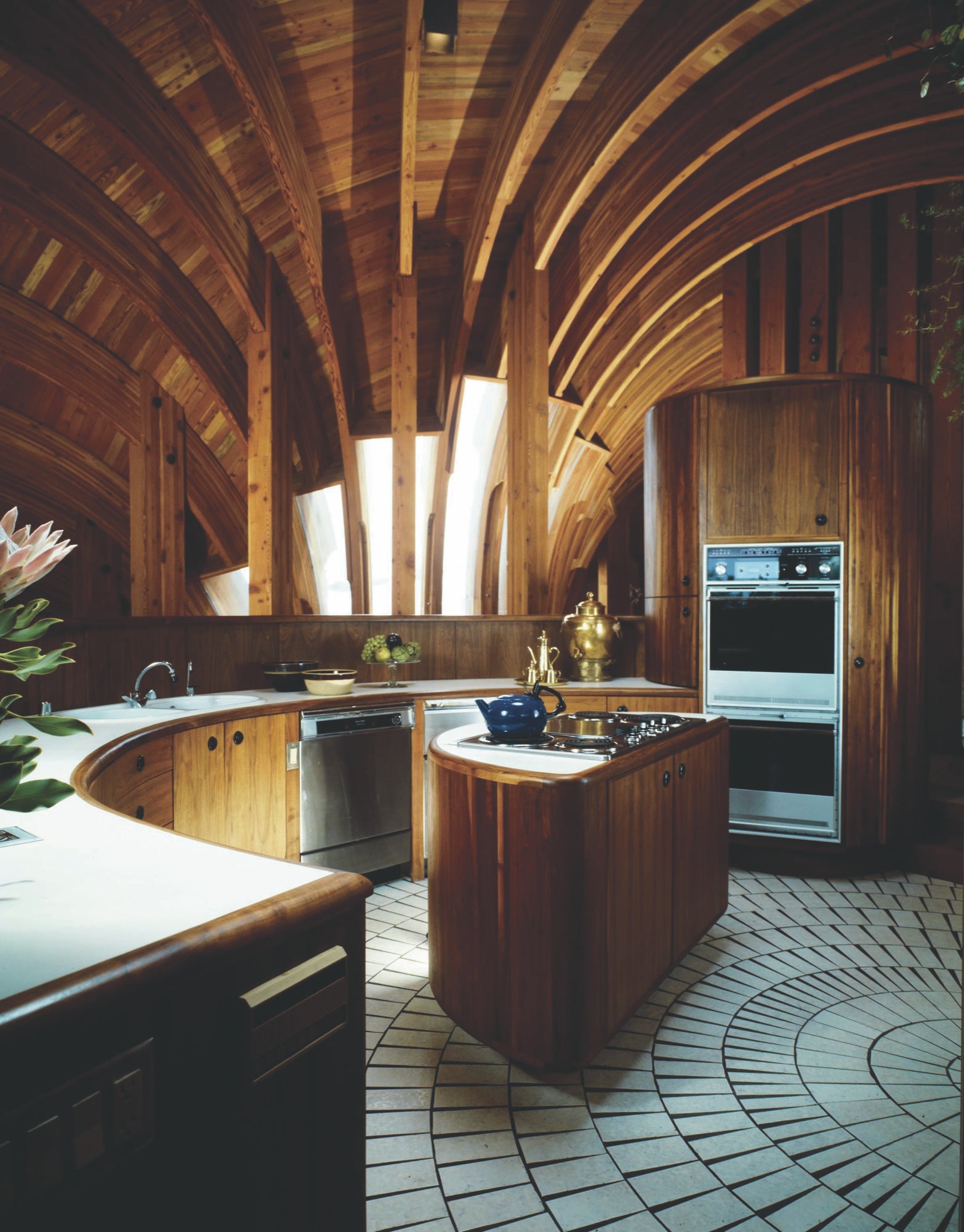 Curved timber beams and cabinetry in the Yen House kitchen