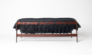 black leather sofa with straps and braziilan hardwood.